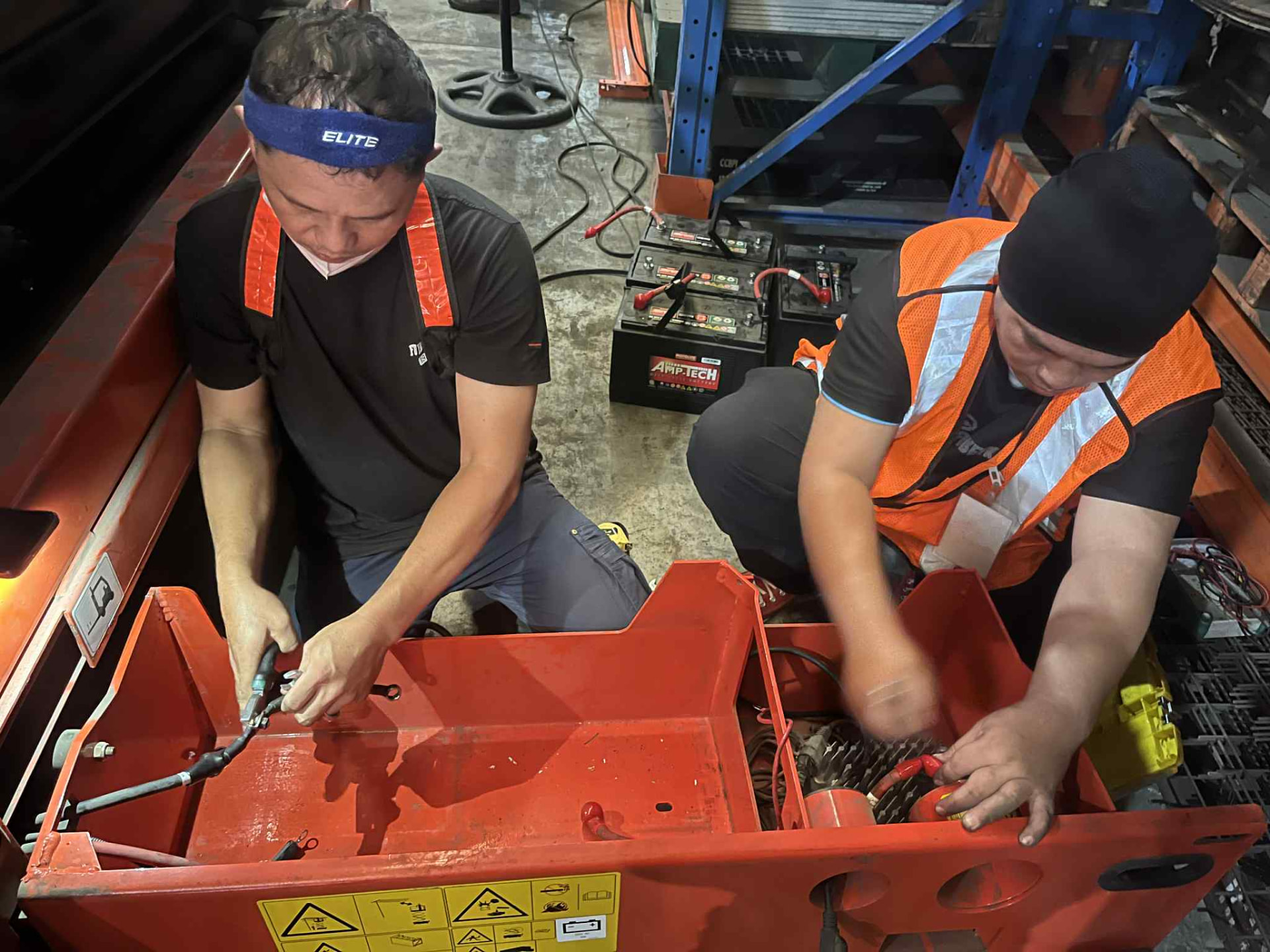 J.A.S technicians working inside a forklift battery compartment
